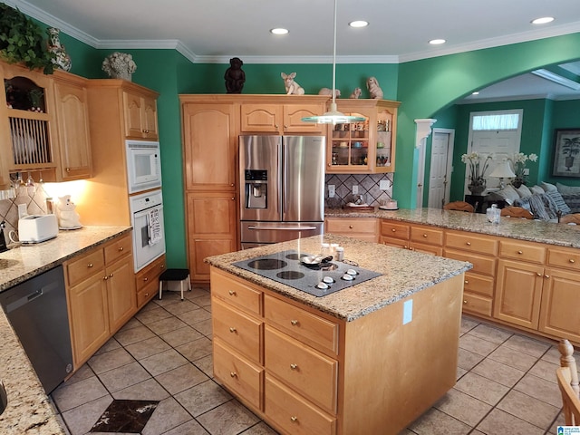 kitchen featuring white appliances, arched walkways, decorative backsplash, a center island, and light brown cabinets