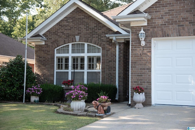 view of front of house featuring a front lawn, brick siding, and an attached garage