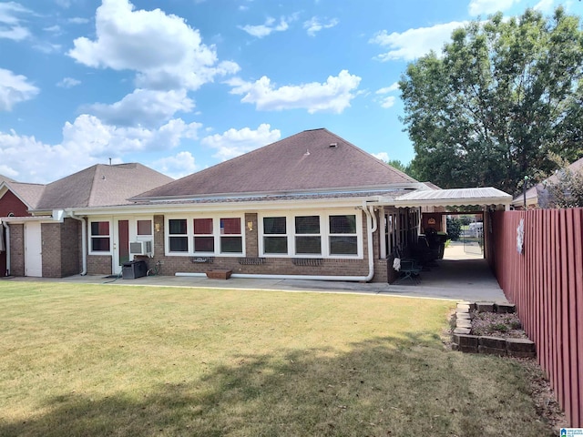 rear view of house with brick siding, a lawn, a patio area, and fence