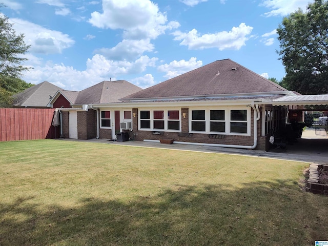 back of property featuring brick siding, a lawn, a shingled roof, and fence