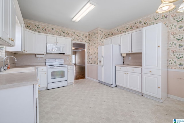 kitchen featuring white appliances, sink, and white cabinets