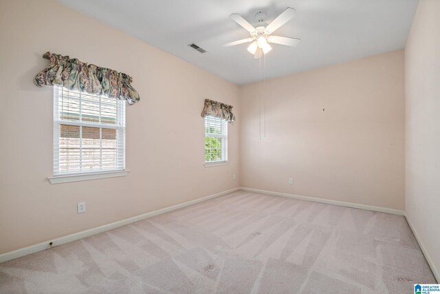 spare room with ceiling fan and light carpet