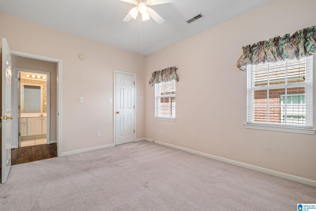 unfurnished bedroom featuring a ceiling fan, carpet, visible vents, and baseboards