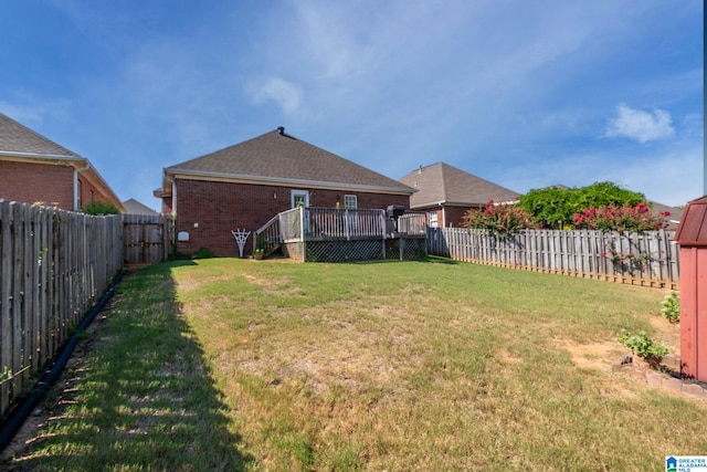 view of yard with a wooden deck and a fenced backyard