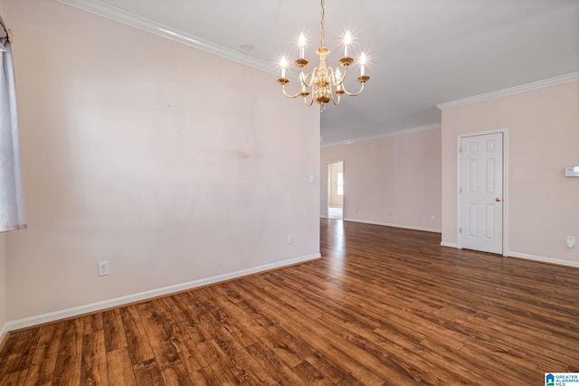 empty room with an inviting chandelier, crown molding, wood finished floors, and baseboards