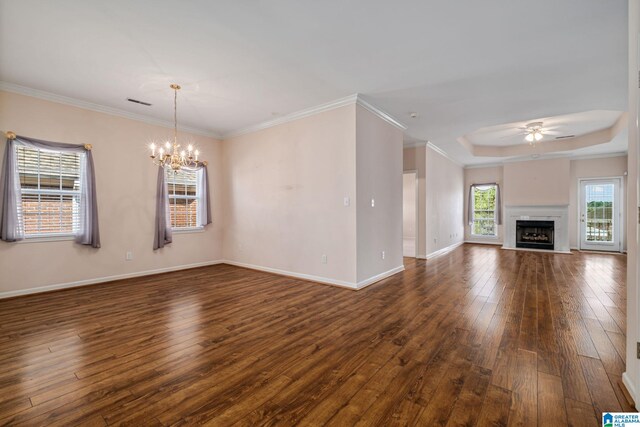 unfurnished living room featuring crown molding, a high end fireplace, ceiling fan with notable chandelier, and dark hardwood / wood-style flooring