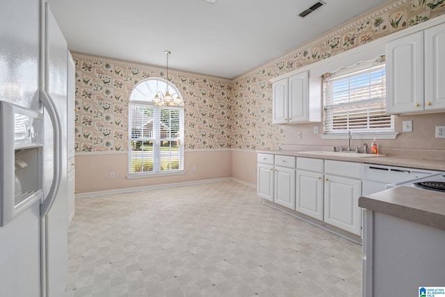 kitchen with hanging light fixtures, sink, a chandelier, white fridge with ice dispenser, and white cabinets