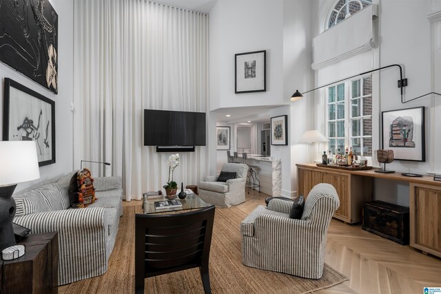 living room with light parquet floors and a towering ceiling