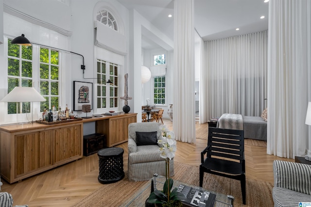 living room featuring light parquet floors and a towering ceiling