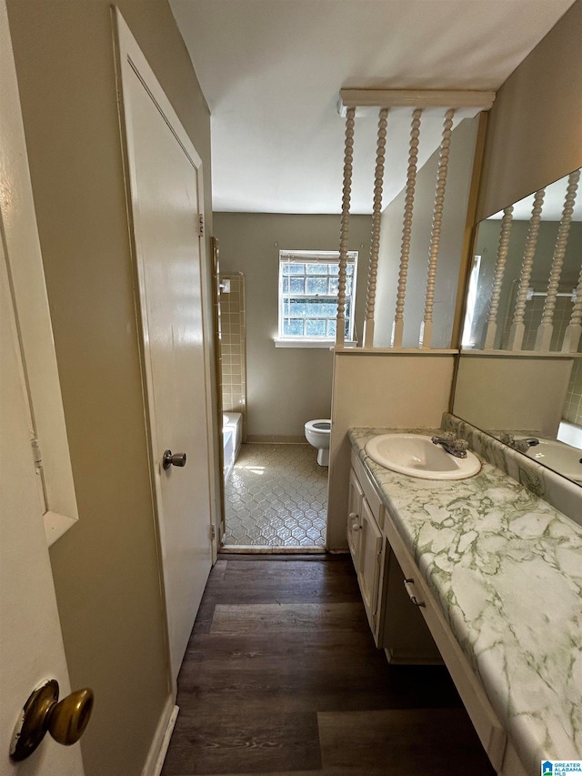 full bathroom with toilet, wood finished floors, and vanity