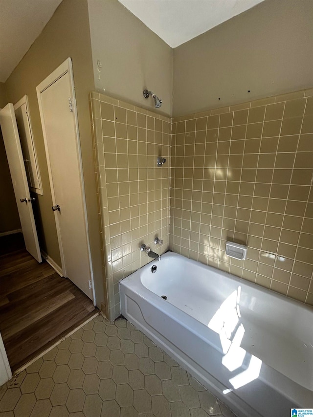 bathroom with a tub to relax in and tile patterned floors