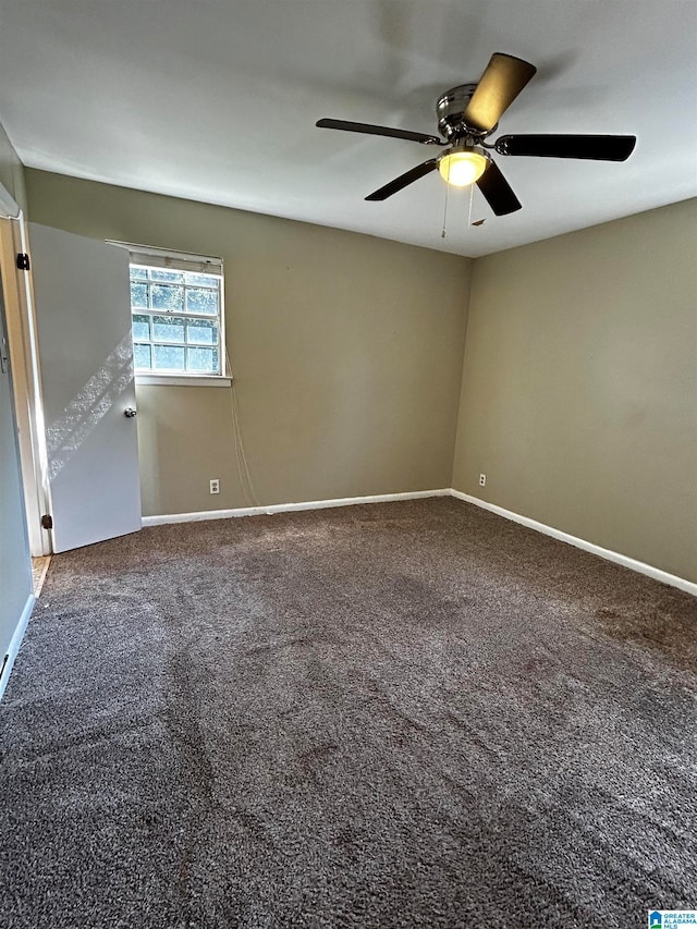 carpeted spare room with a ceiling fan and baseboards