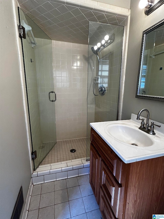 full bath with a shower stall, visible vents, tile patterned flooring, and vanity