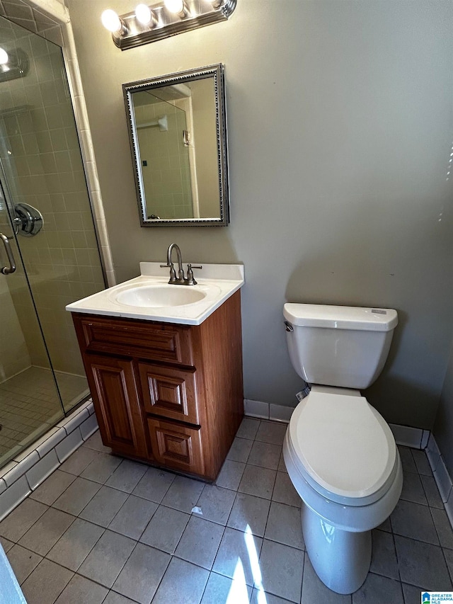 bathroom featuring baseboards, toilet, tile patterned flooring, vanity, and a shower stall