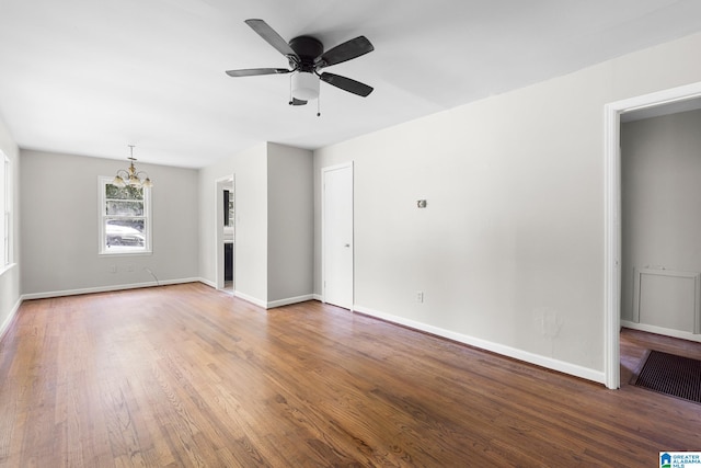 unfurnished living room featuring hardwood / wood-style floors and ceiling fan with notable chandelier