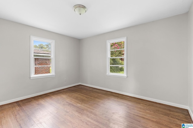 empty room with baseboards and wood finished floors