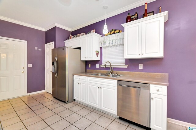 kitchen featuring decorative light fixtures, appliances with stainless steel finishes, ornamental molding, sink, and white cabinets