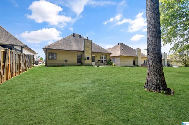 back of house with a yard and a patio area