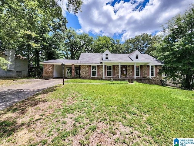 view of front facade with aphalt driveway, a carport, and a front yard