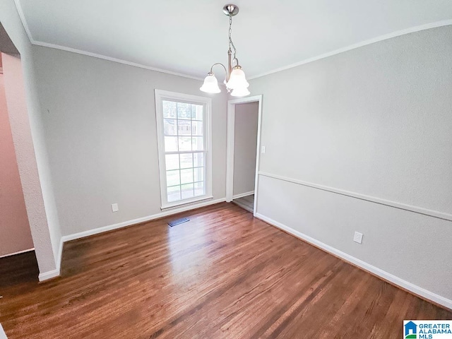 spare room with crown molding, an inviting chandelier, and hardwood / wood-style flooring