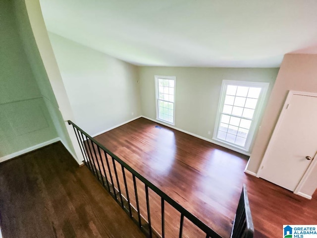 stairs featuring plenty of natural light and wood-type flooring