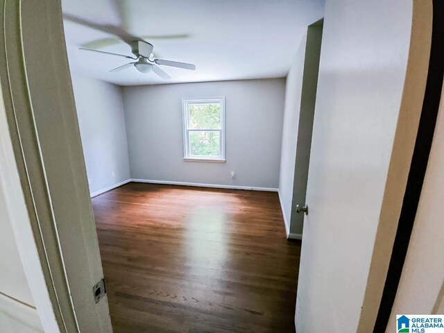 spare room with dark wood-type flooring and ceiling fan