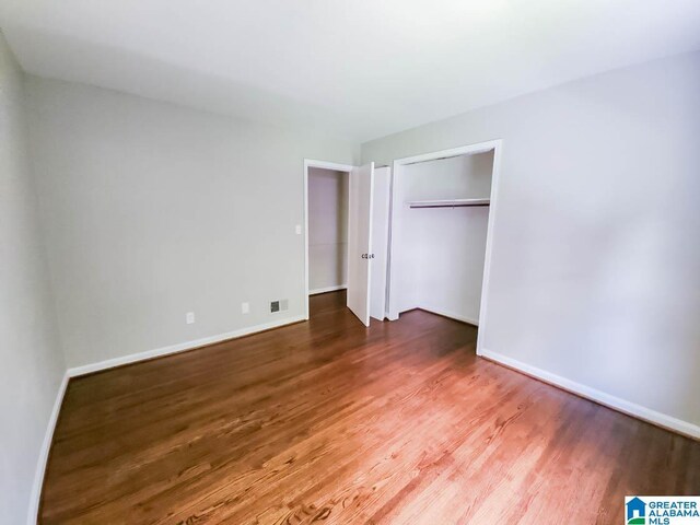 unfurnished bedroom featuring hardwood / wood-style floors and a closet