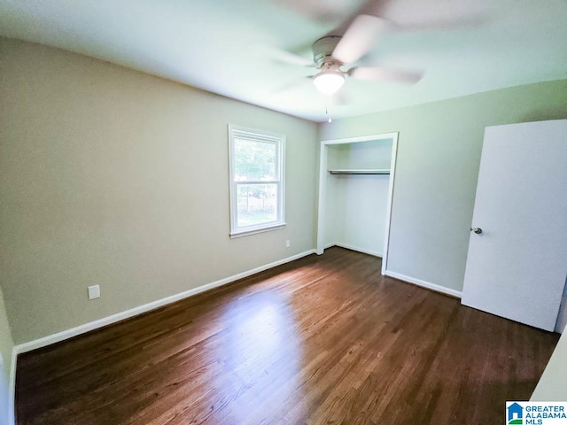 unfurnished bedroom featuring dark wood-type flooring, ceiling fan, and a closet