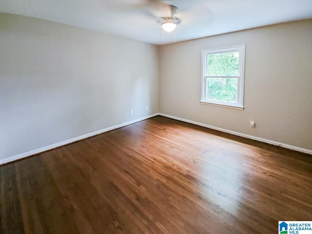 empty room featuring ceiling fan and dark hardwood / wood-style flooring