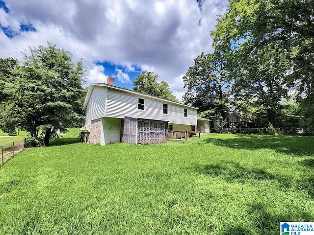 rear view of property with a lawn