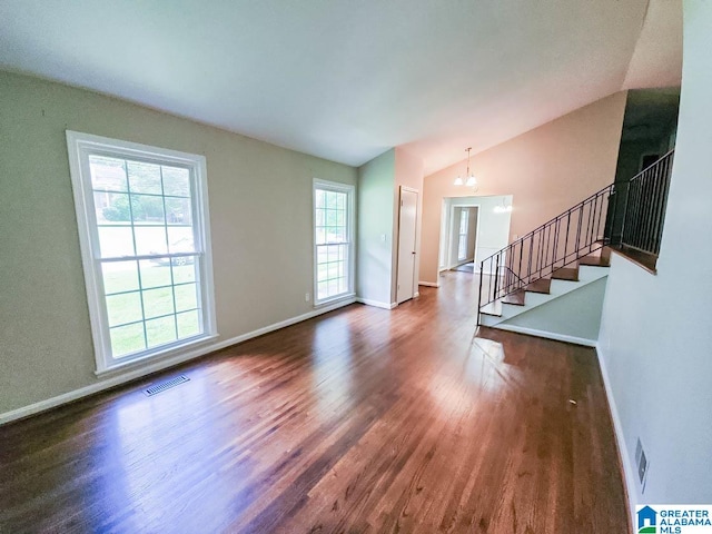 unfurnished living room with lofted ceiling, an inviting chandelier, and dark hardwood / wood-style flooring