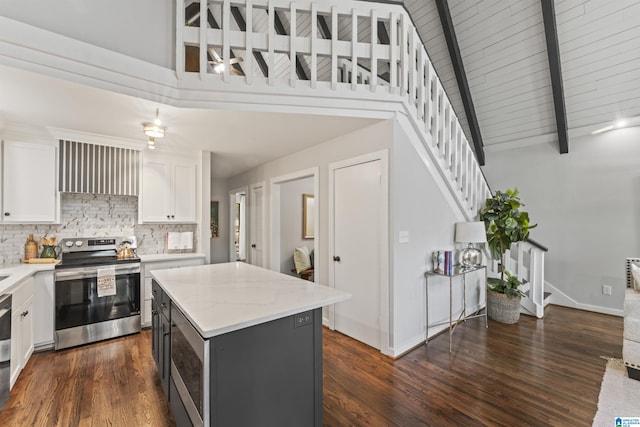kitchen with stainless steel electric range, decorative backsplash, a kitchen island, beamed ceiling, and white cabinets