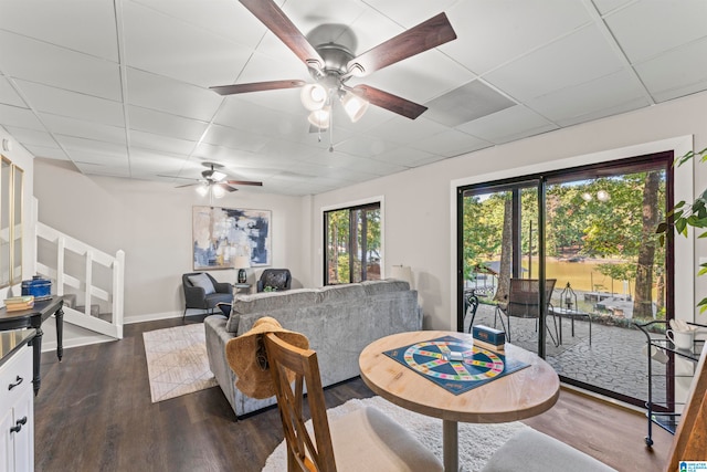 dining space with ceiling fan, dark hardwood / wood-style flooring, and a drop ceiling