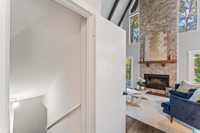 living room featuring dark hardwood / wood-style floors, high vaulted ceiling, and a fireplace