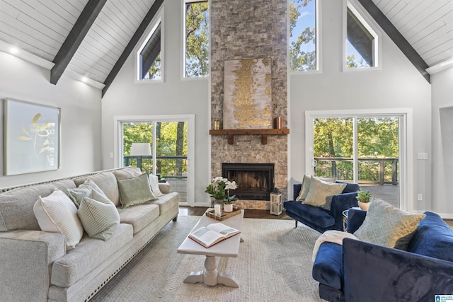 living area featuring wooden ceiling, high vaulted ceiling, beamed ceiling, a fireplace, and wood finished floors