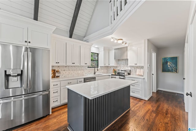 kitchen featuring a center island, vaulted ceiling with beams, appliances with stainless steel finishes, and white cabinets