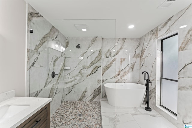 bathroom featuring plus walk in shower, tile walls, and vanity