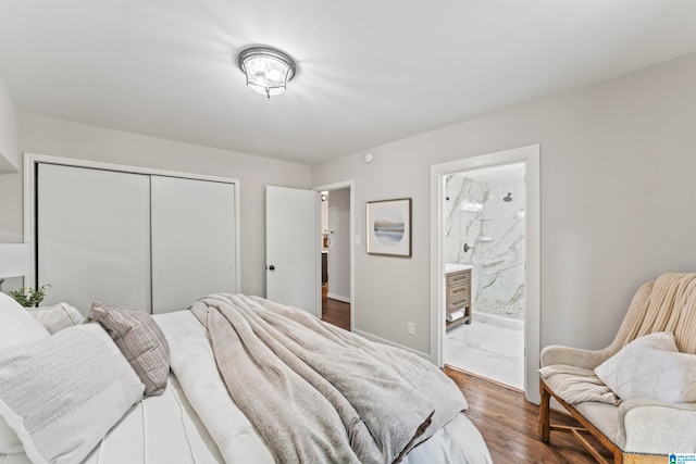 bedroom with dark hardwood / wood-style flooring, ensuite bathroom, and a closet