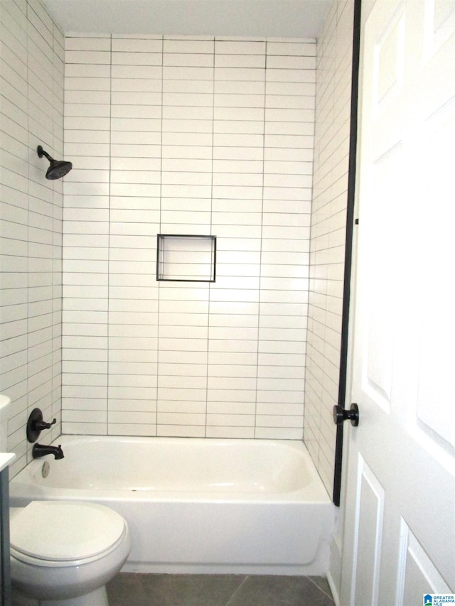 bathroom with toilet, tiled shower / bath combo, and tile patterned floors