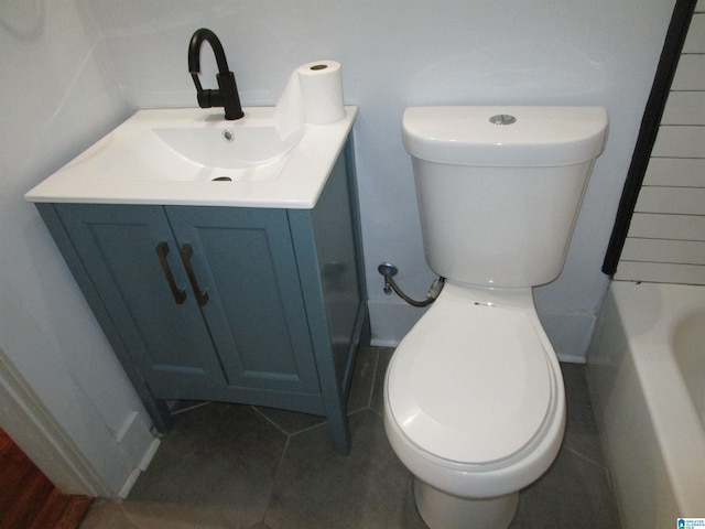 bathroom featuring vanity, toilet, a bathing tub, and tile patterned floors