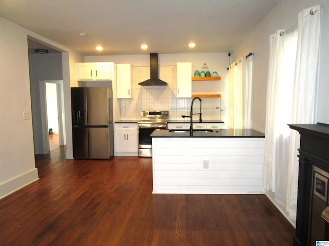 kitchen featuring appliances with stainless steel finishes, white cabinetry, sink, wall chimney range hood, and dark hardwood / wood-style floors