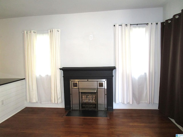 unfurnished living room with dark wood-type flooring and a healthy amount of sunlight