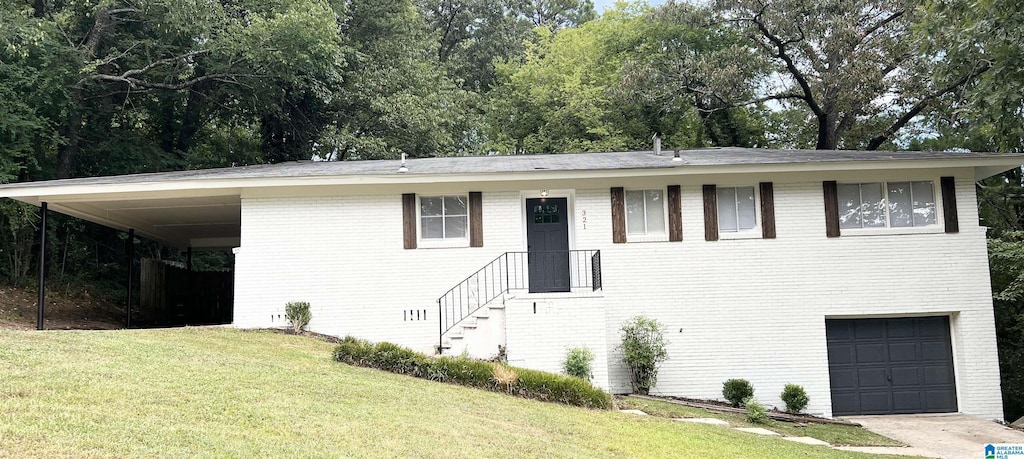 321 Bridlewood Dr, Birmingham, AL 35215 - view of front facade featuring brick siding, a carport, a garage, driveway, and a front lawn