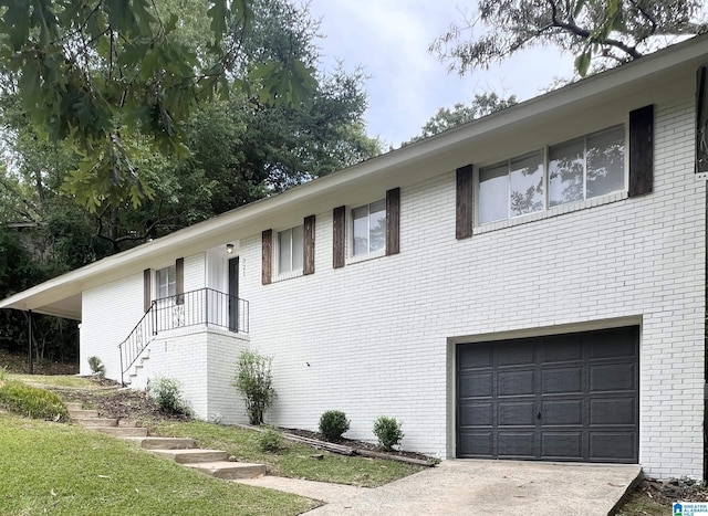 view of front of house with a garage, driveway, and brick siding