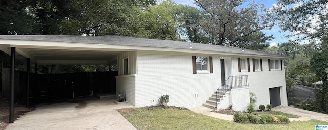 view of front of home featuring brick siding, a garage, crawl space, a carport, and driveway