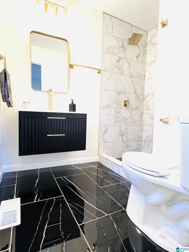 bathroom with marble finish floor, baseboards, a tile shower, and toilet