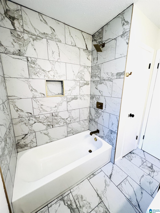 full bathroom featuring marble finish floor, tub / shower combination, and a textured ceiling