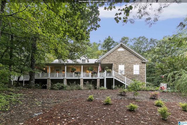 rear view of house featuring stone siding and stairway