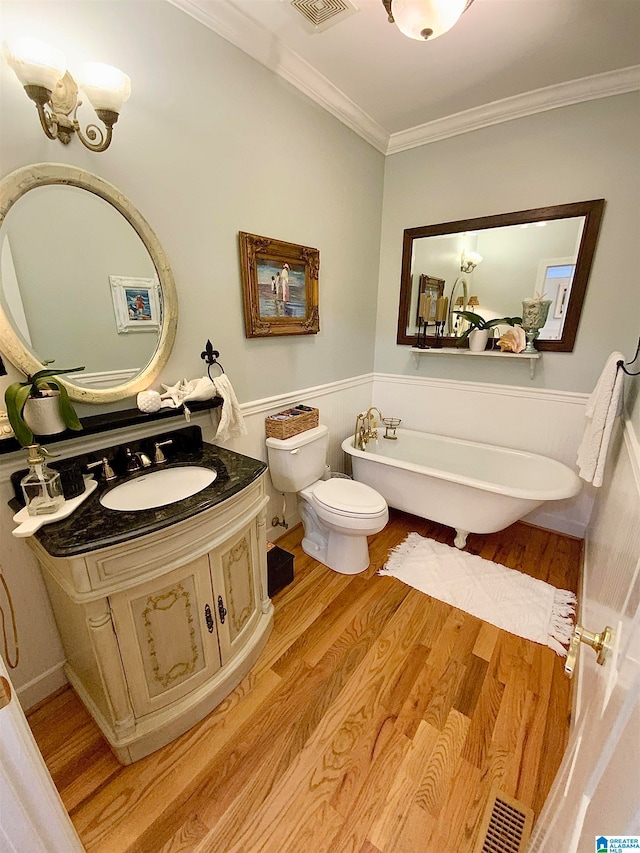 bathroom with a tub, vanity, toilet, ornamental molding, and hardwood / wood-style flooring