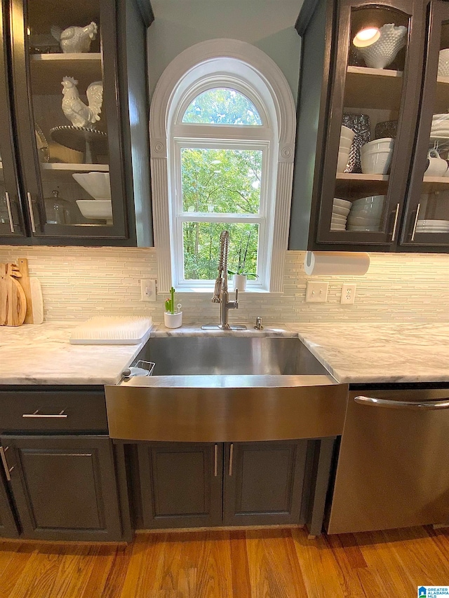 kitchen with dishwasher, backsplash, sink, and light hardwood / wood-style floors